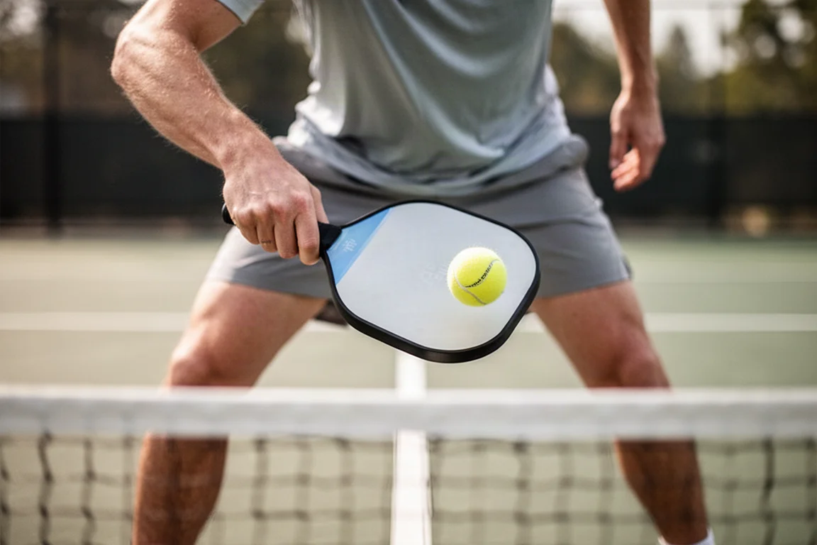 Giocatore di pickleball che esegue un dink morbido alla linea della cucina