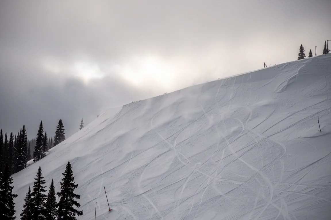 Pared nevada con nieve afectada por el viento en una estación, con huellas tenues