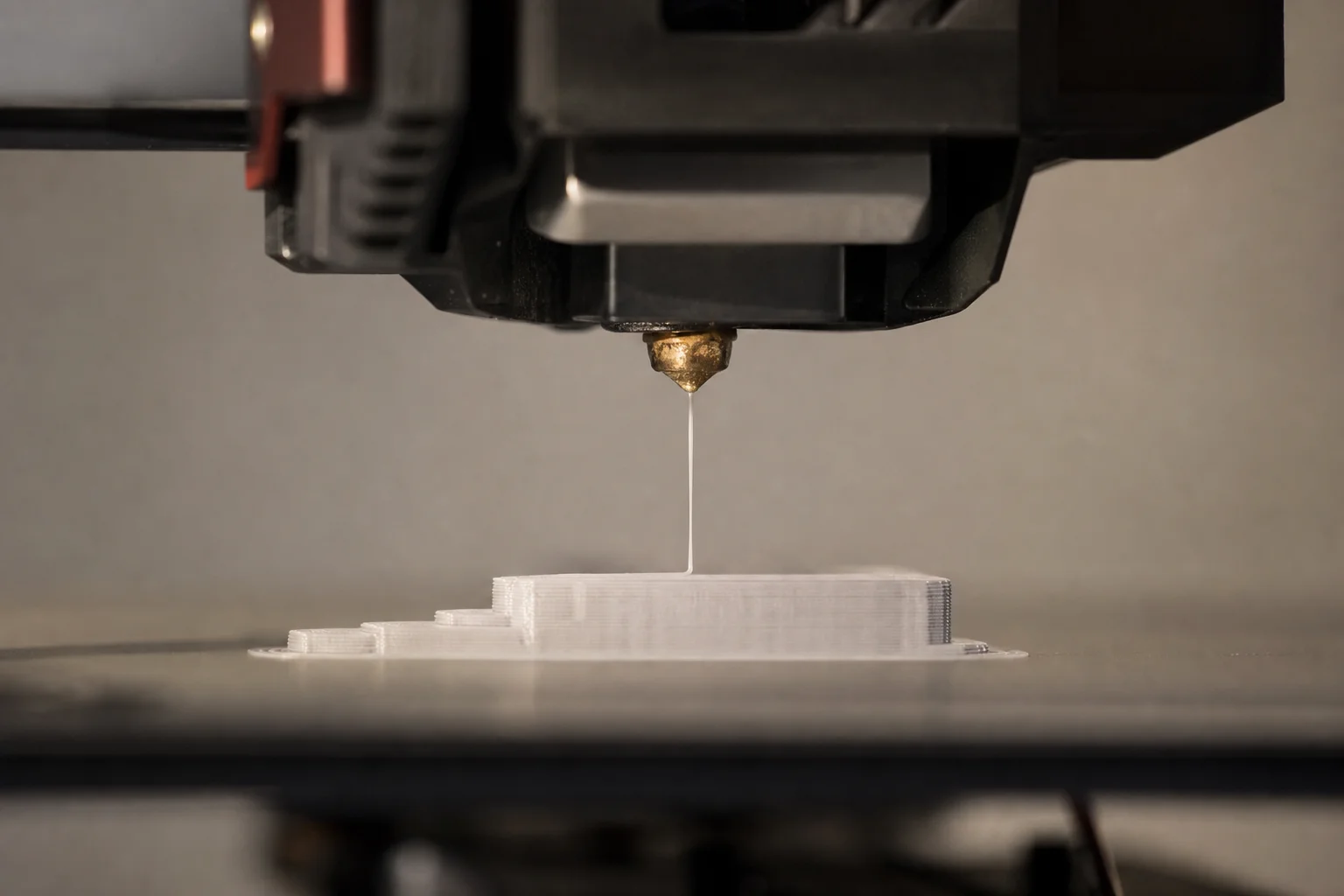3D 打印機噴嘴在加熱平台上擠出耗材的特寫