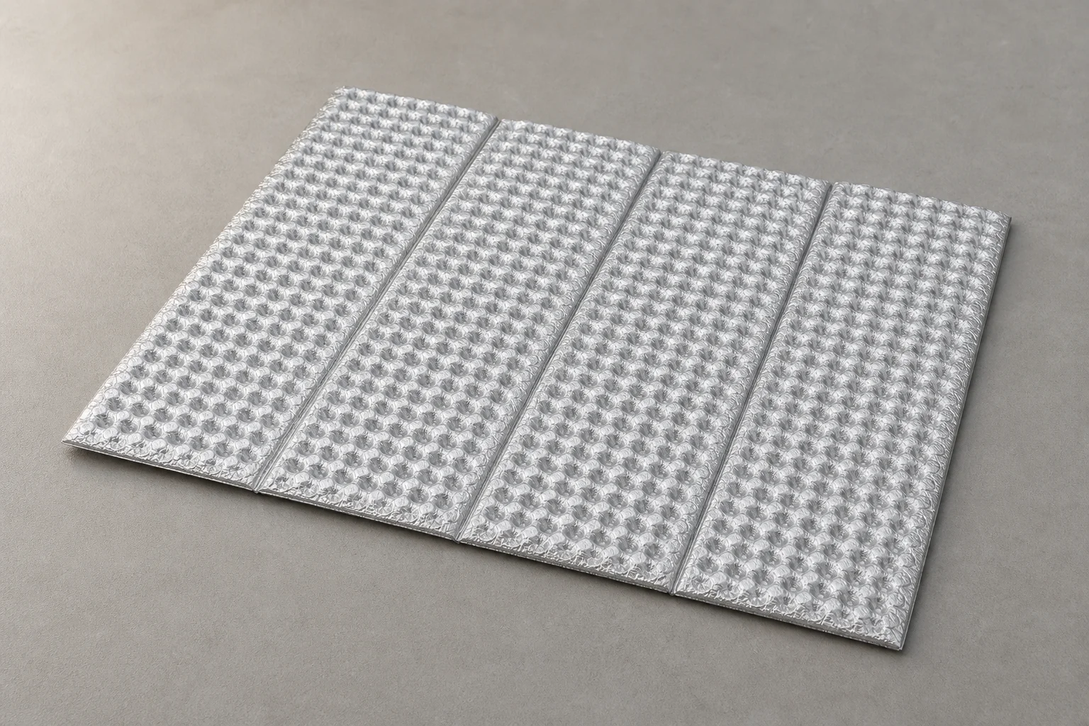 Layered sleep system components displayed flat showing mat, liner, bag, and bivvy