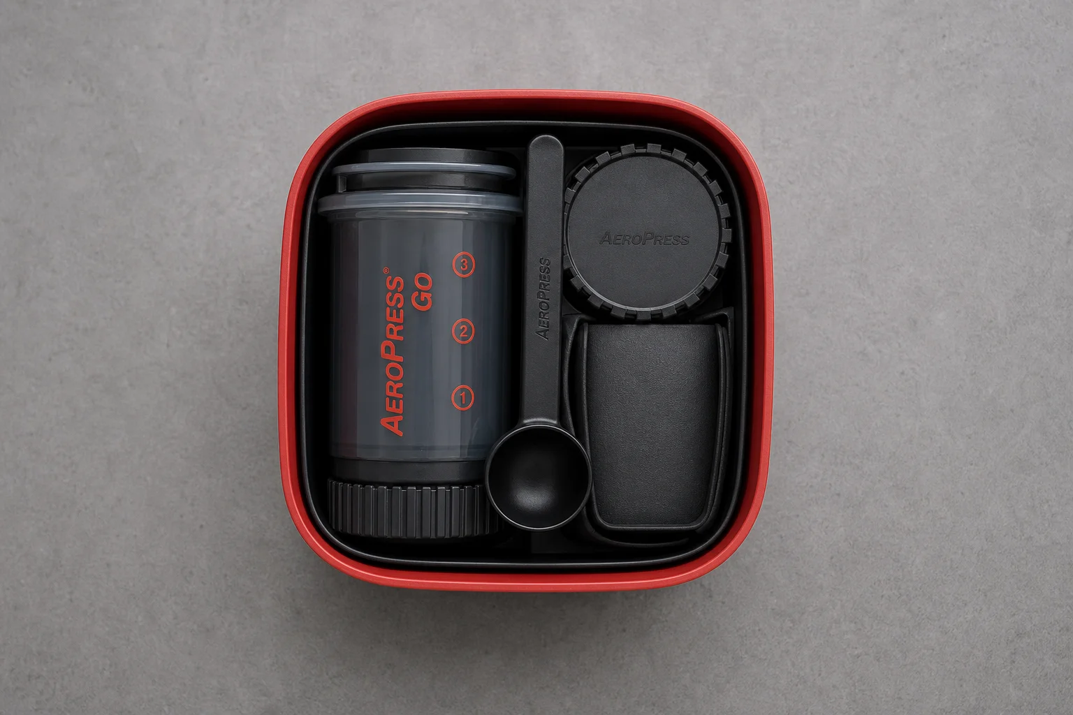 Aeropress Go packed components nested inside the red travel lid