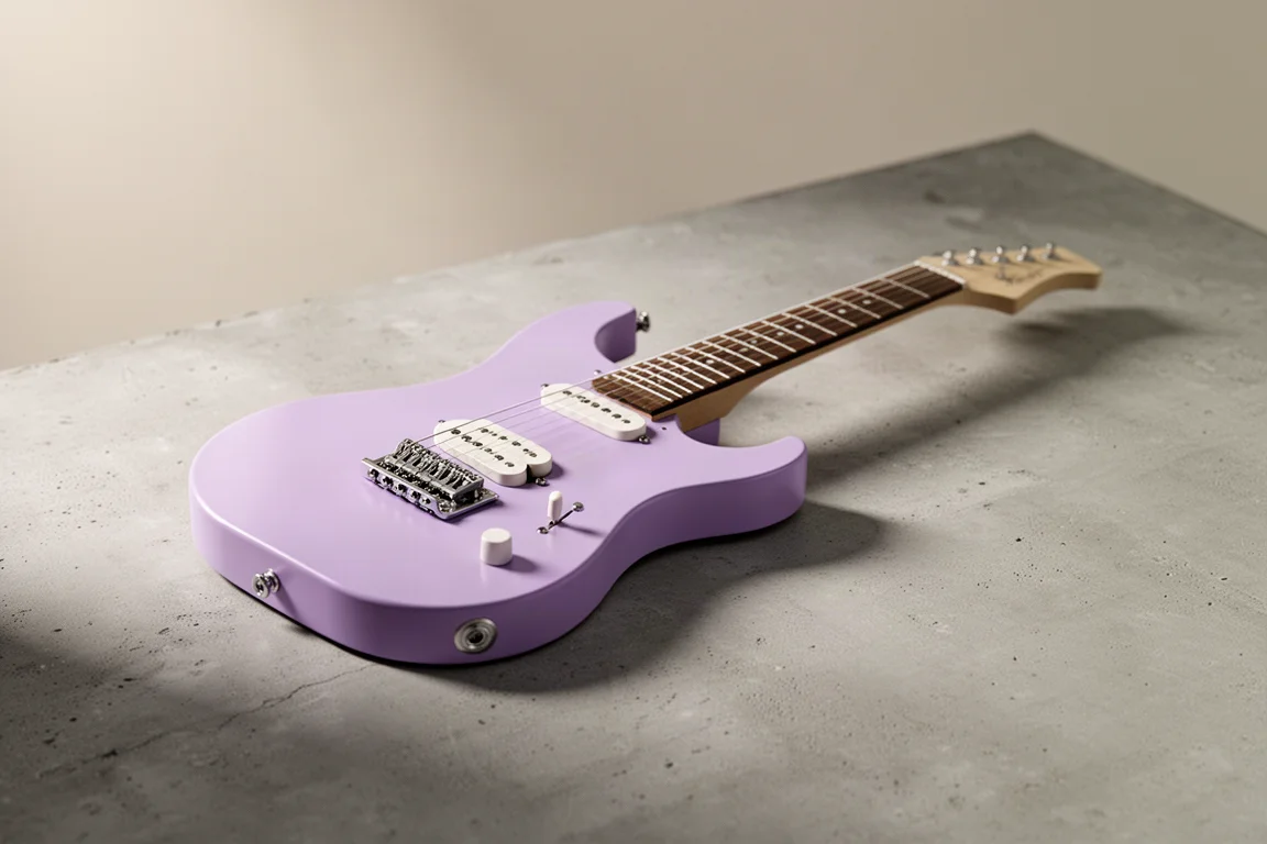 Chitarra mini AKLOT per bambini in finitura lavanda su una superficie di cemento