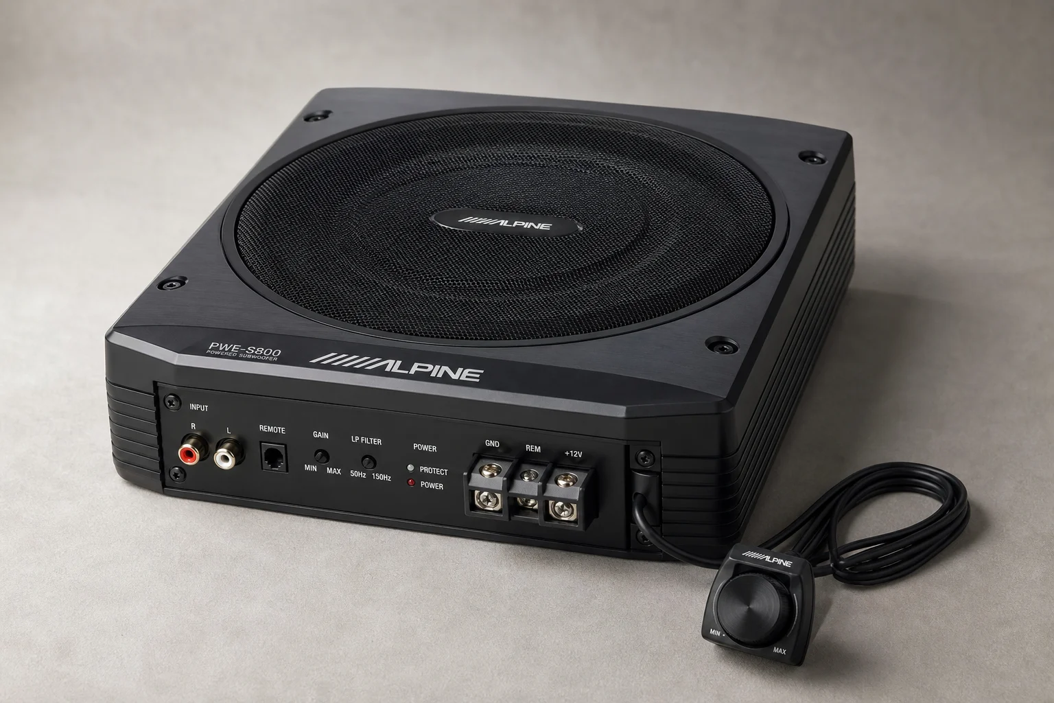 Five compact under-seat subwoofers arranged on dark surface showing various models and sizes