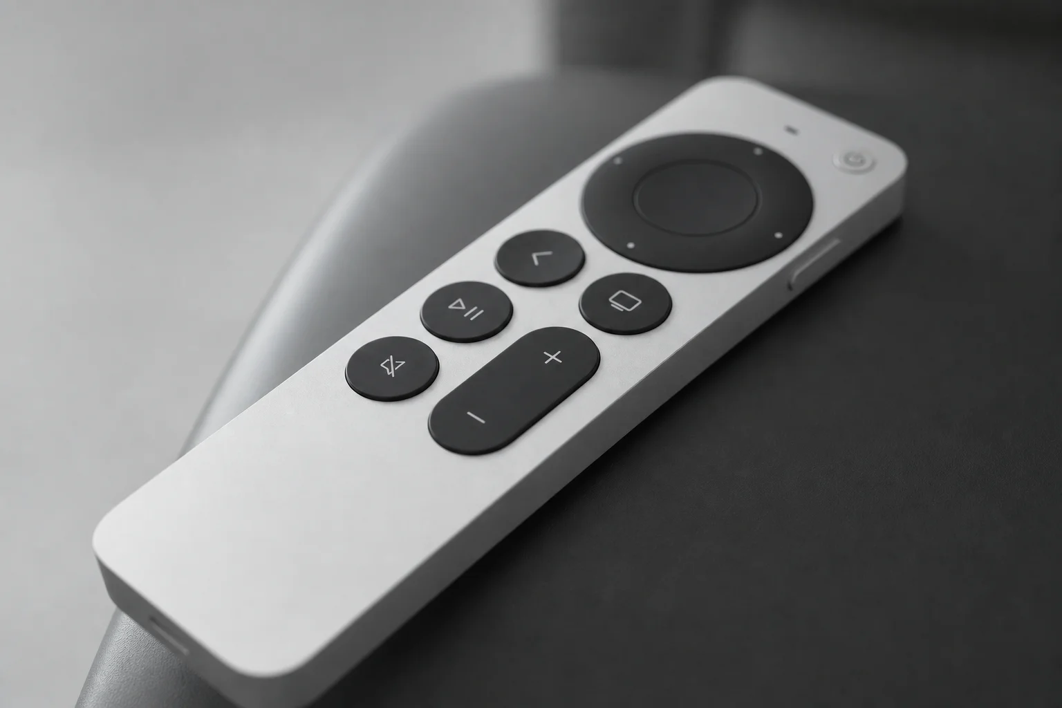 Close-up of Apple TV remote control with illuminated buttons