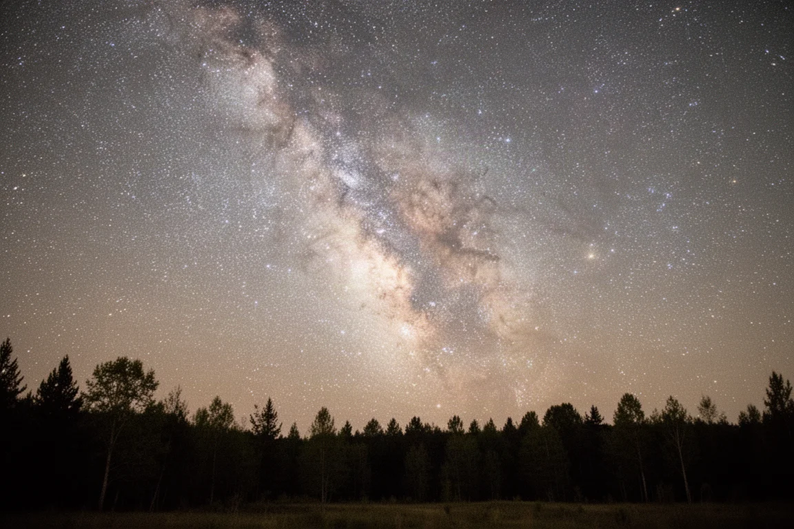 寧靜地景上方蘊含豐富星雲細節的廣角夜空
