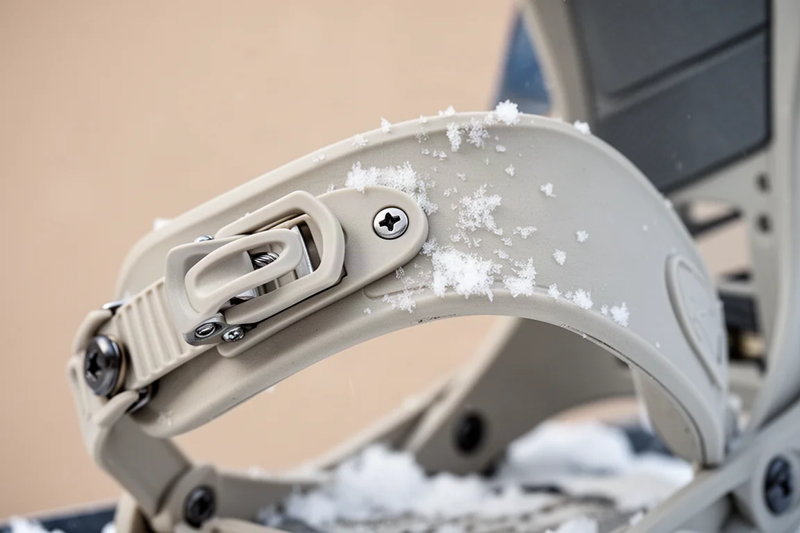 Close-up of a snowboard binding's toe strap and twist tab adjustment