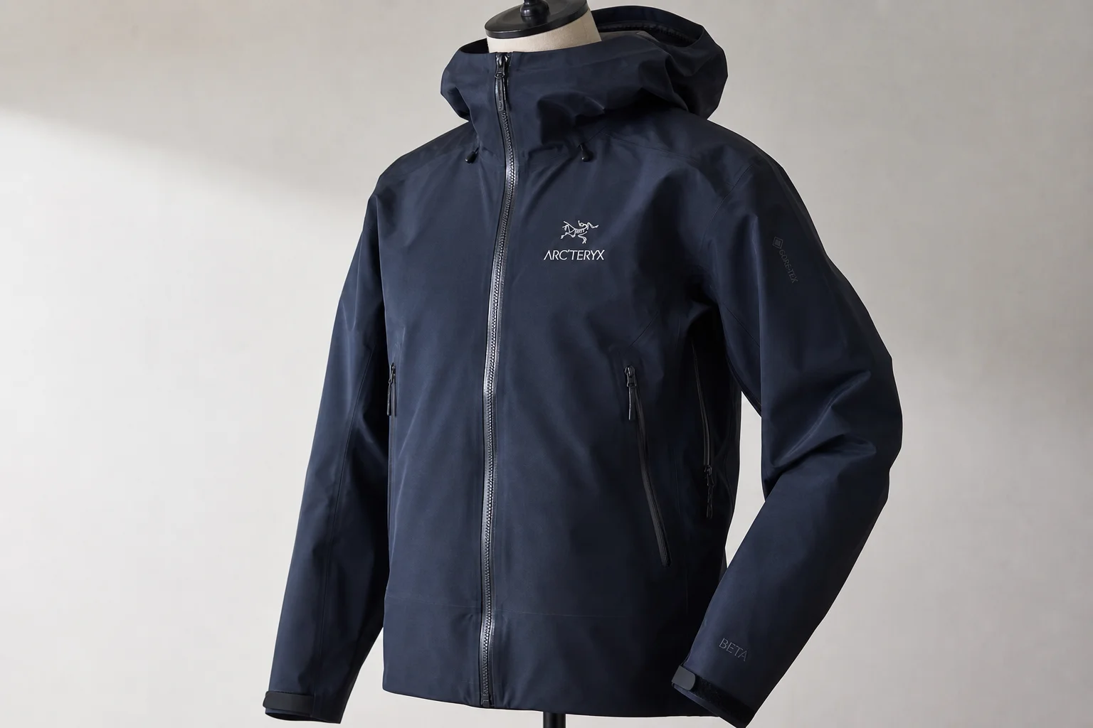 Cinco chaquetas impermeables de diferentes colores y estilos dispuestas sobre hormigón