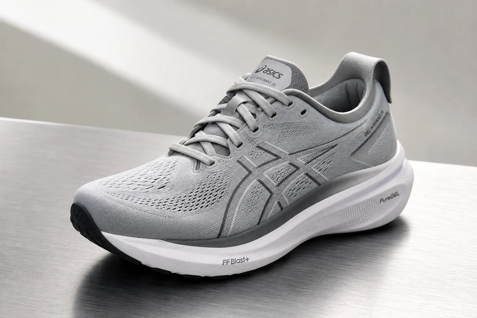 Three running shoes displayed side by side on concrete: Asics Gel Kayano 31, Brooks Ghost 16, and ON Cloudsurfer 7