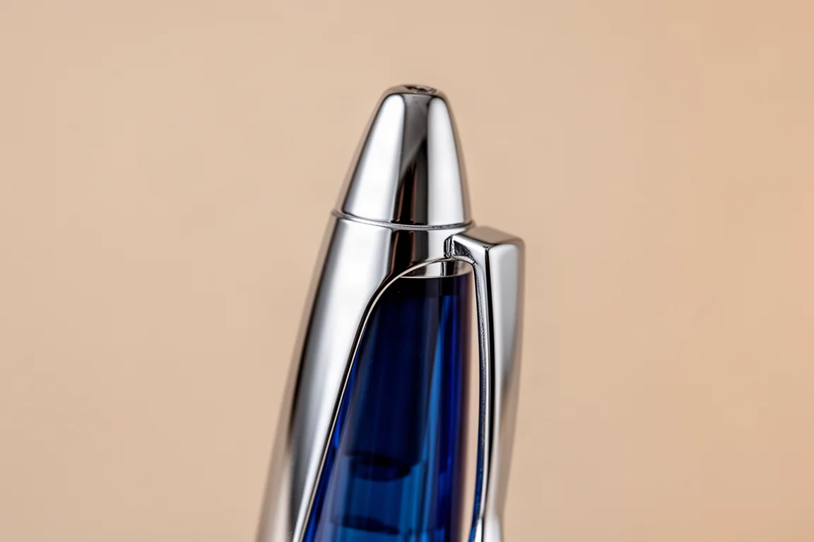 Close-up van een metalen vulpenklem en dop bovenop op een neutrale ondergrond