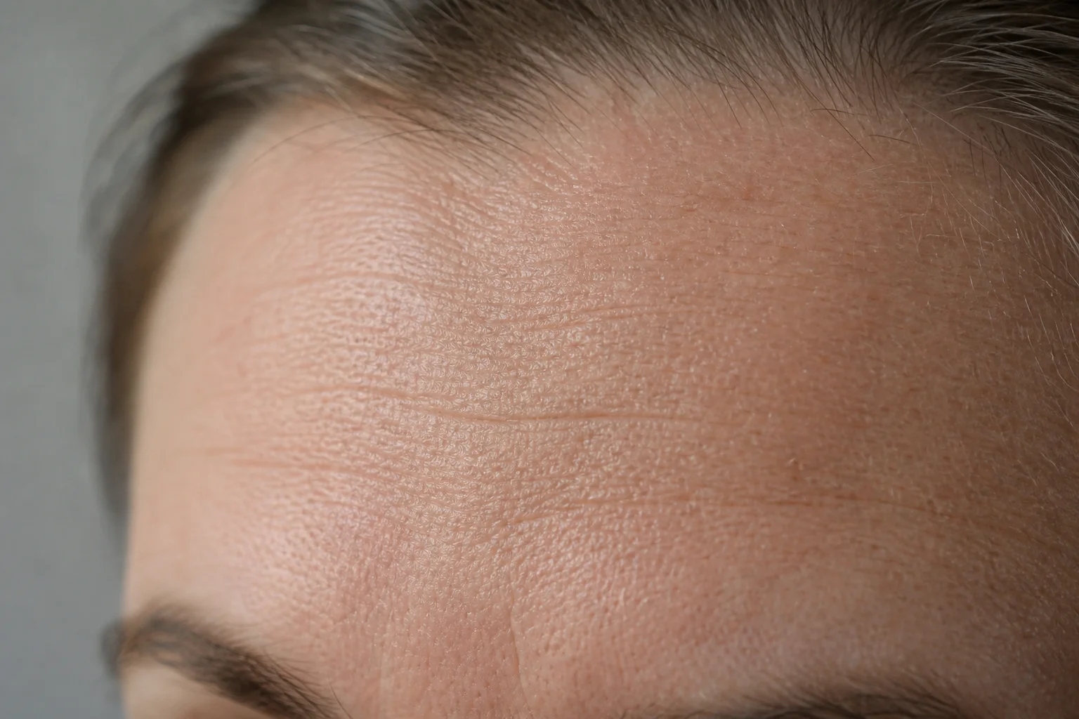 Close-up of facial skin texture showing fine lines and wrinkles in natural light