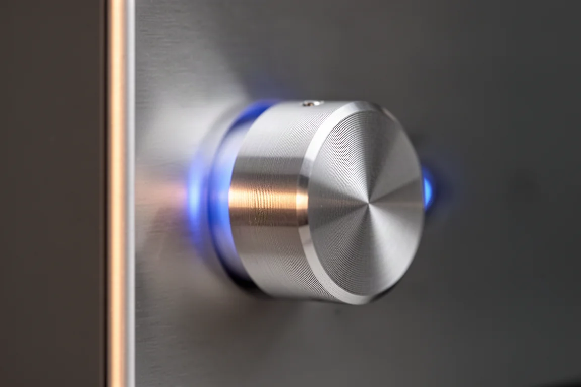 Close-up of a machined aluminium amplifier knob with a soft blue indicator light behind it