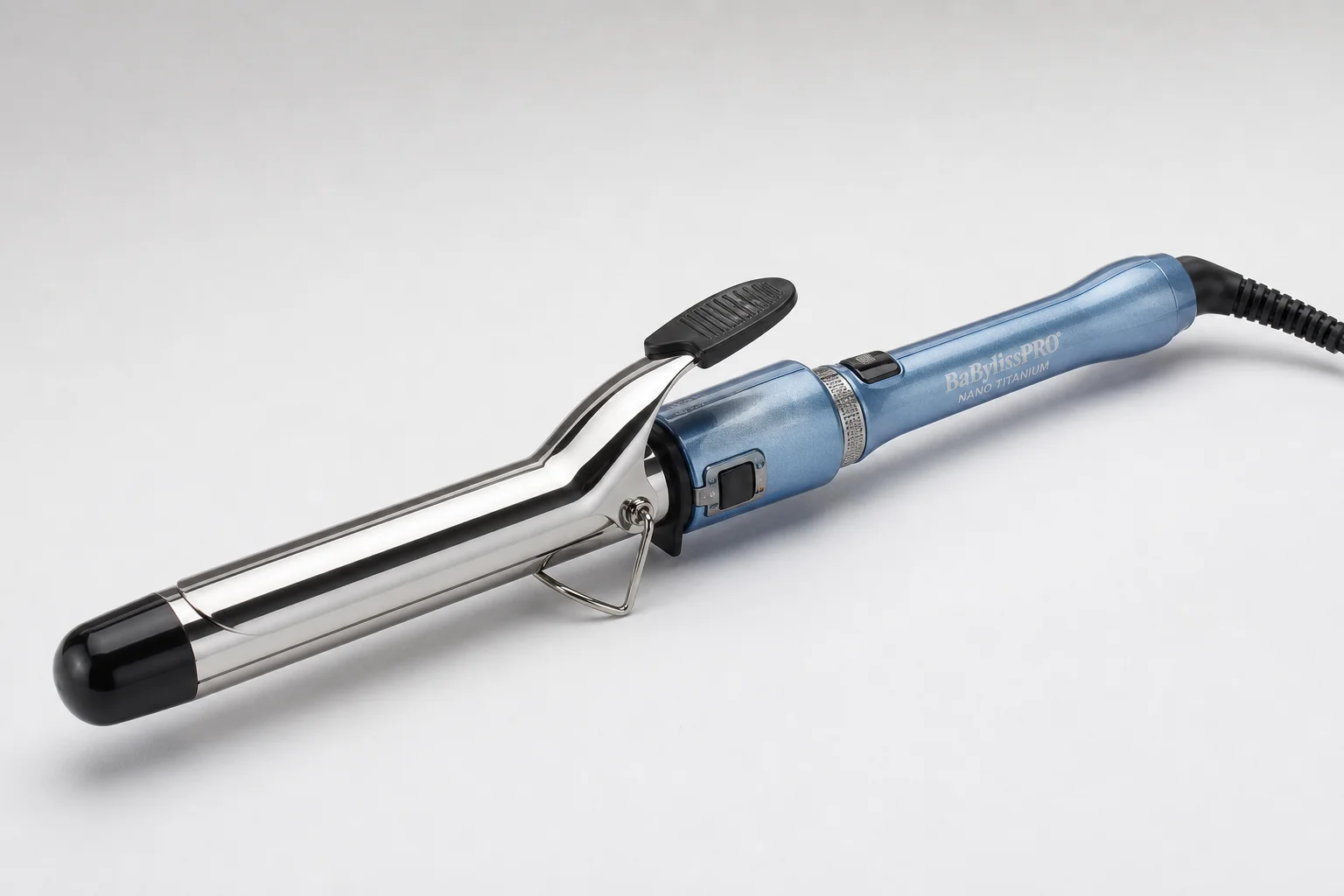 Five curling irons in various sizes arranged on a marble surface