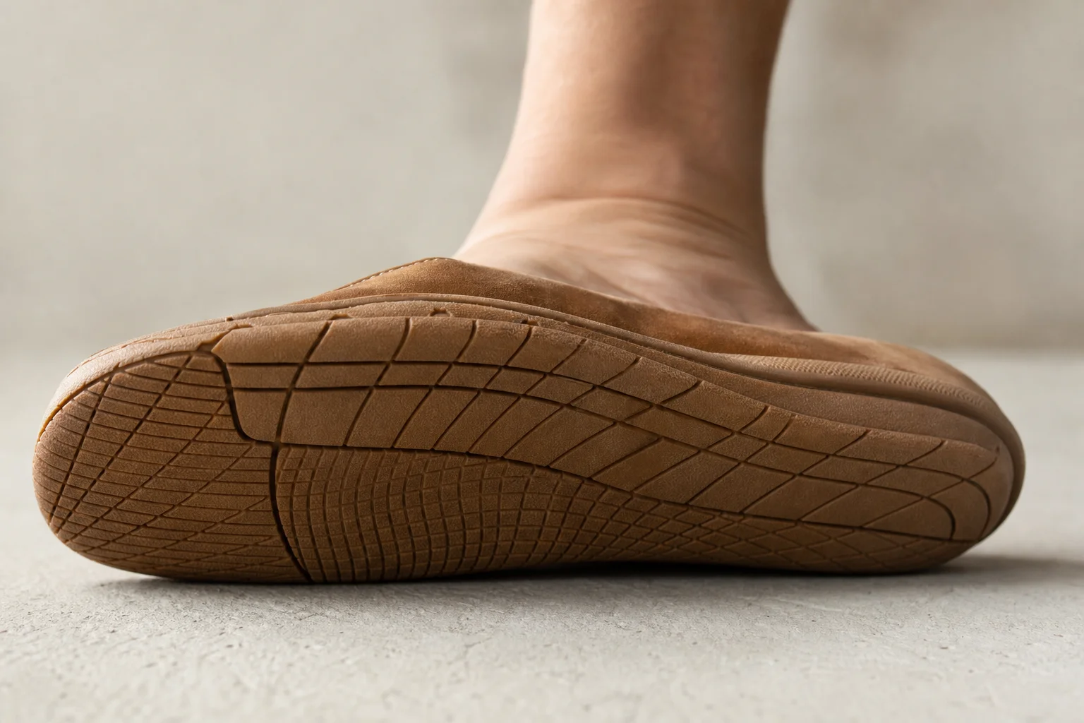 Gros plan sur la semelle d'une chaussure barefoot montrant une adhérence minimale et le contact au sol