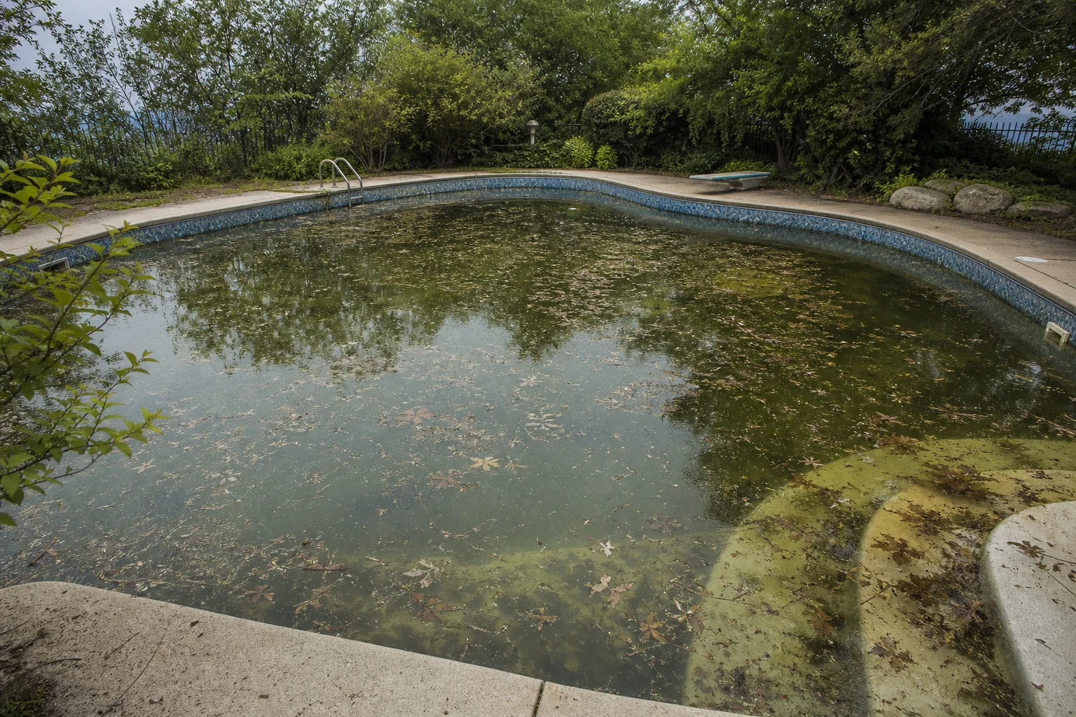 Acqua torbida della piscina piena di foglie, sedimenti e detriti