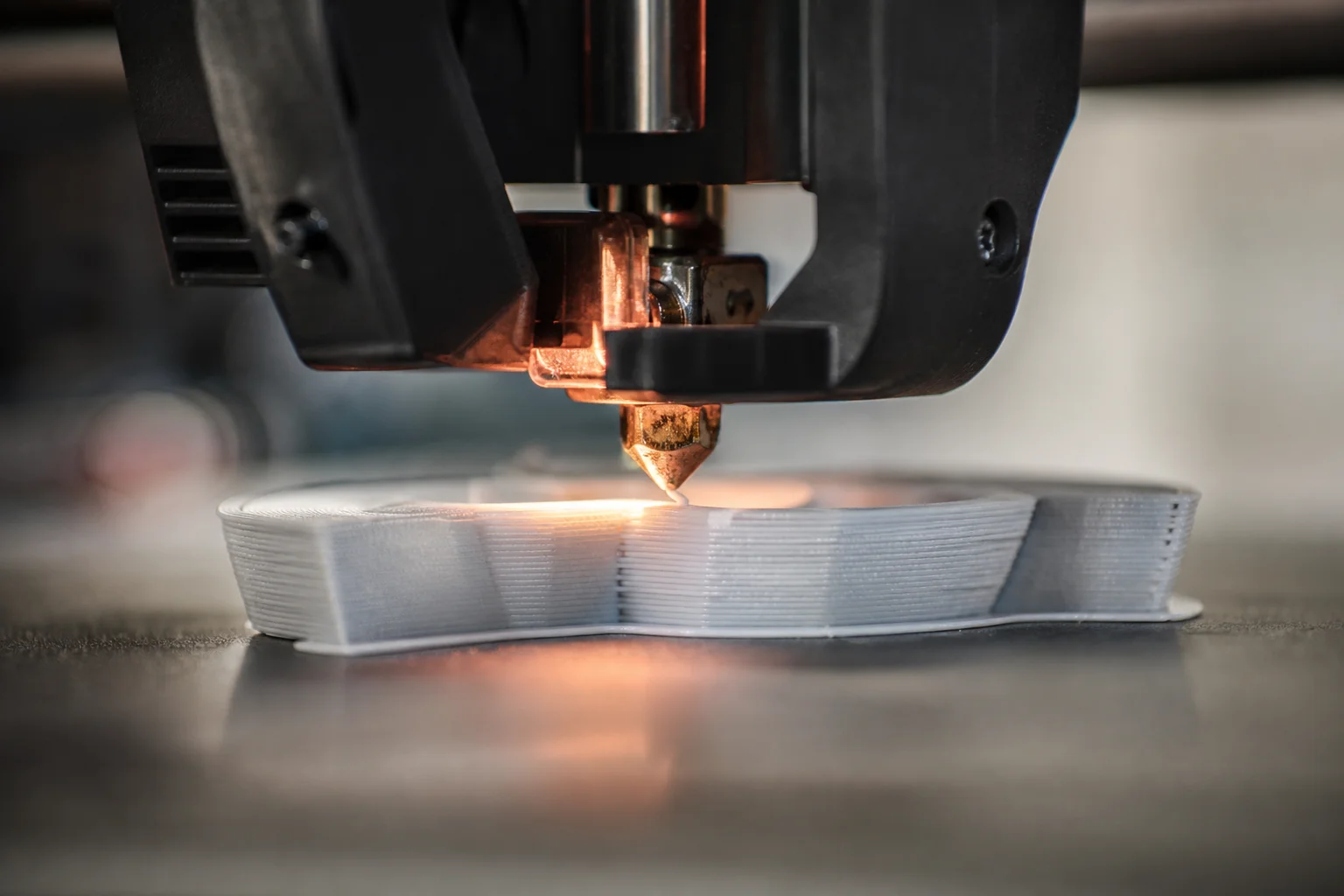 Buse d'imprimante 3D extrudant du filament fondu sur le plateau d'impression