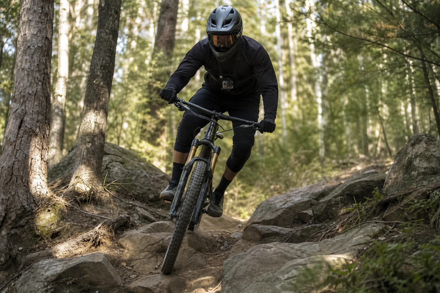 Mountain biker che scende lungo un sentiero con un'action cam montata sul petto