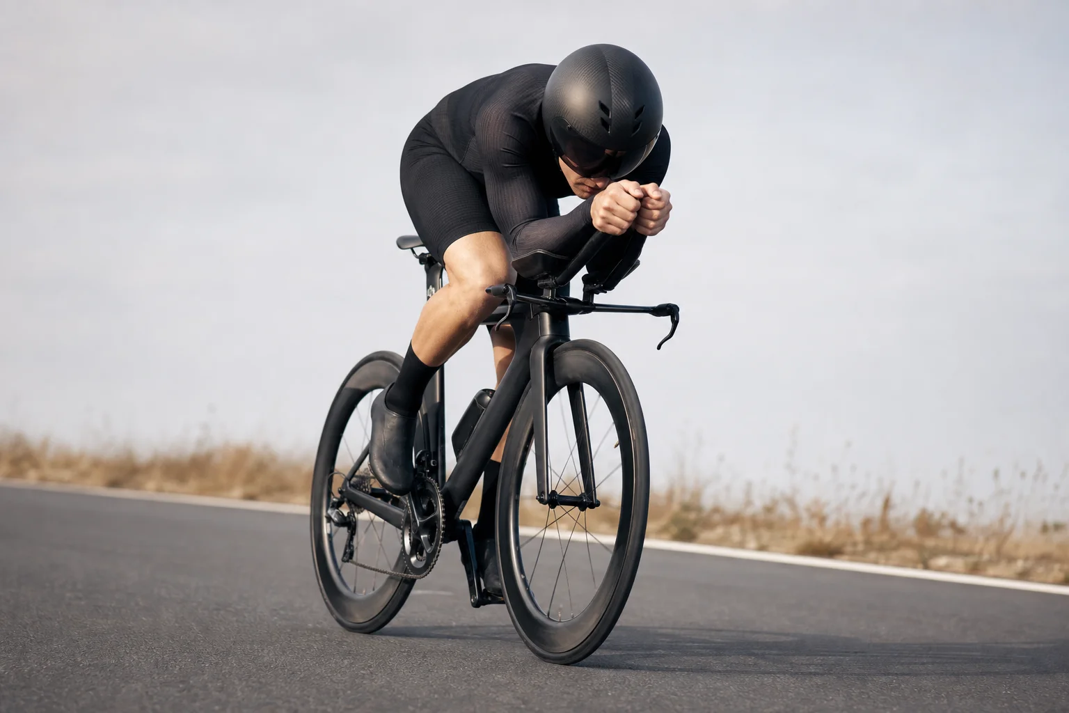 Professional road cyclist in aerodynamic position wearing aero helmet