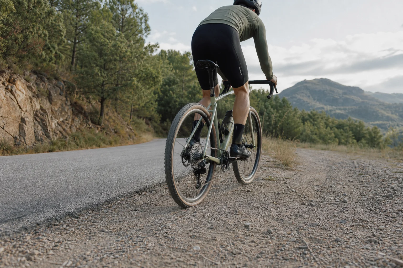 Radfahrer auf einer gemischten Strecke mit Asphalt- und Schotterabschnitten