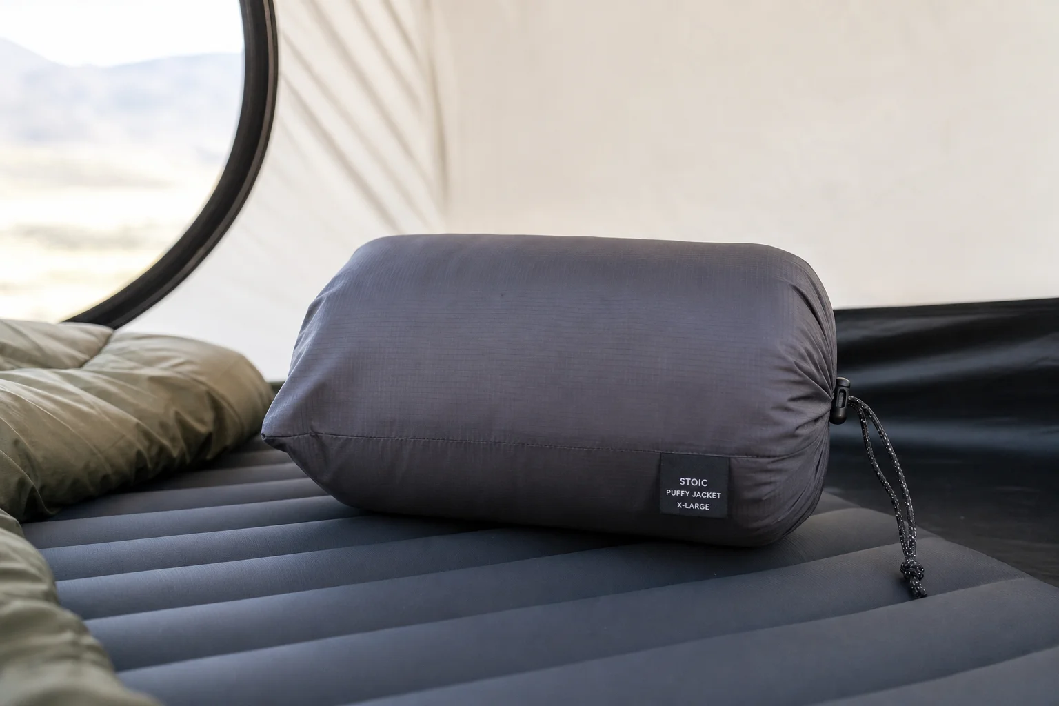 Packsack-Kissen gefüllt mit einer Daunenjacke auf einer Isomatte