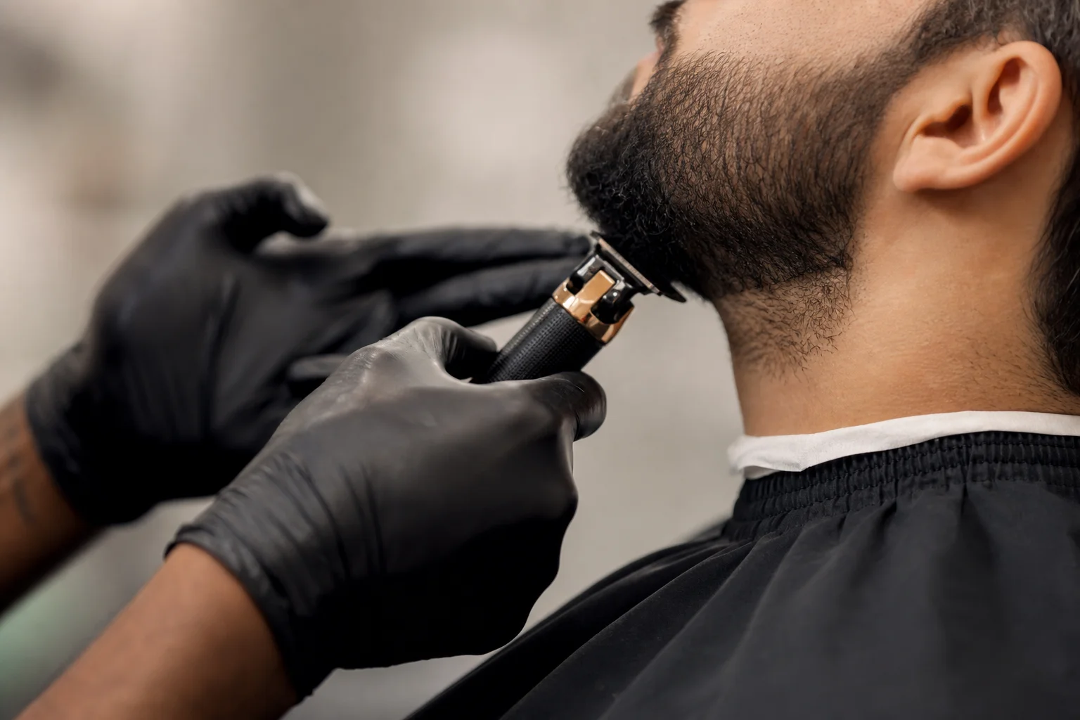Un barbier professionnel utilisant une tondeuse de précision pour des tracés détaillés sur un client