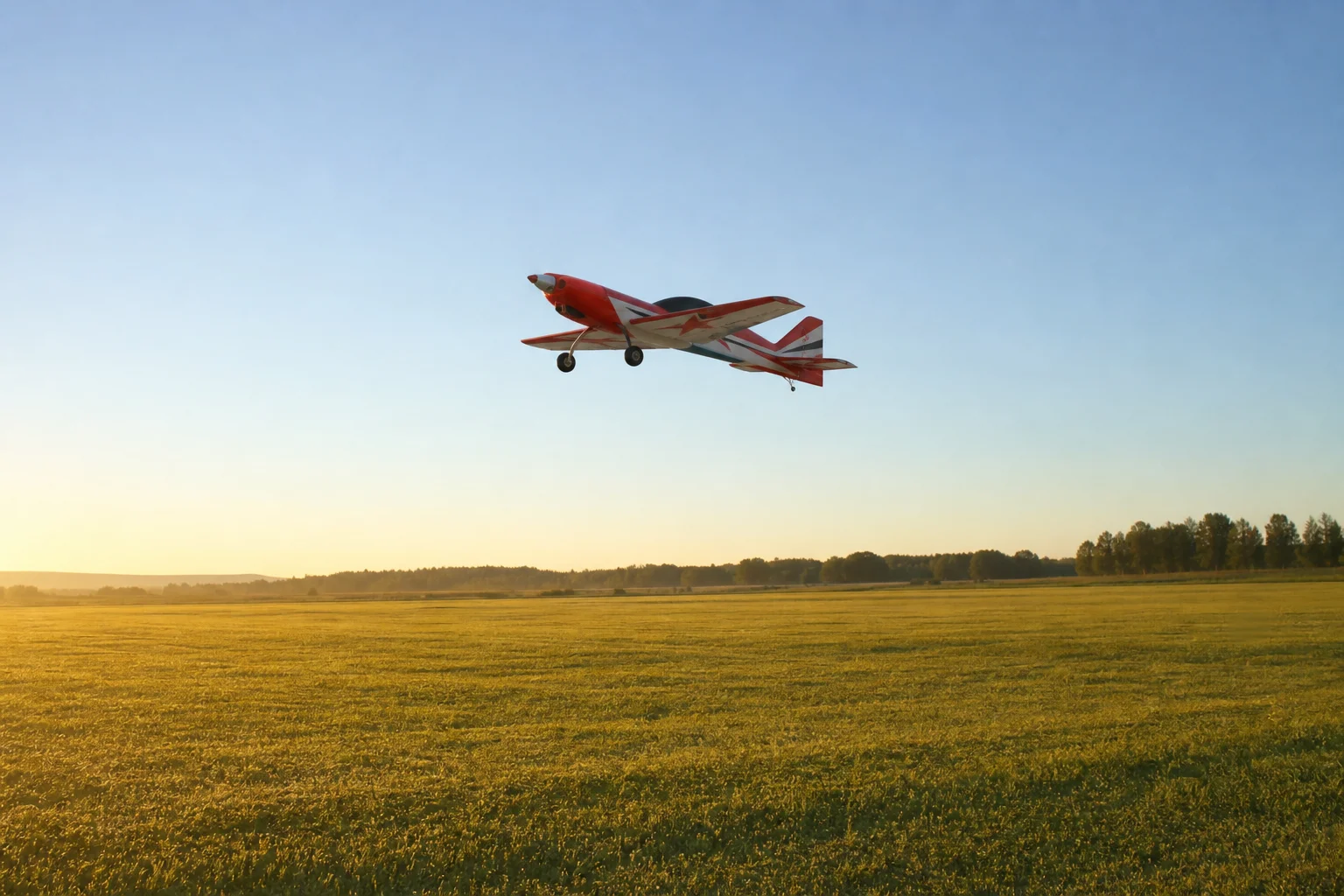 RC plane launching from an open grass field at dawn