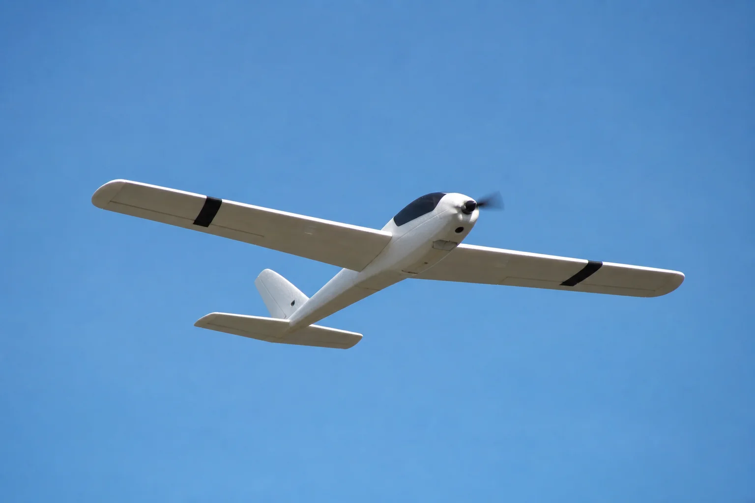 Foam RC aircraft in flight against a clear sky