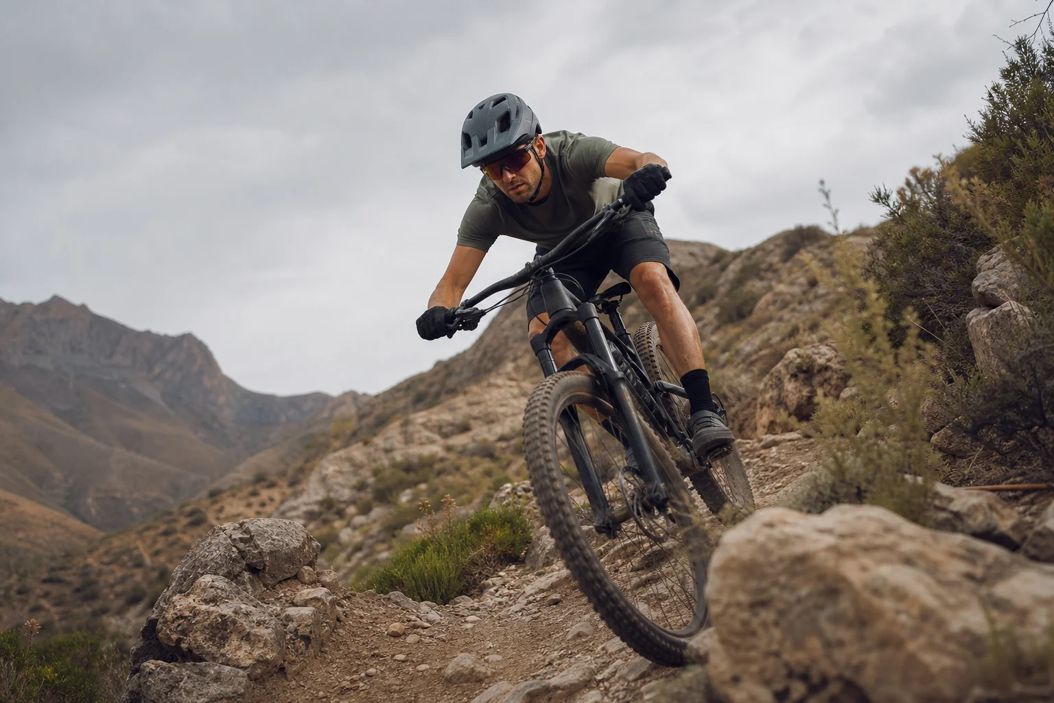 Mountain biker riding on a rocky trail with helmet in motion