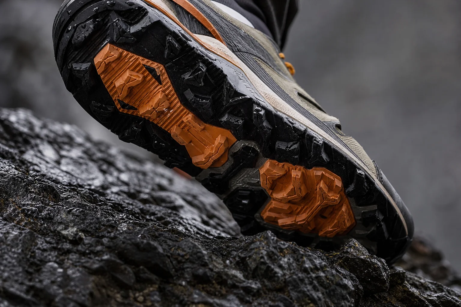 Semelle extérieure de chaussure de trail avec des crampons agrippant une roche humide