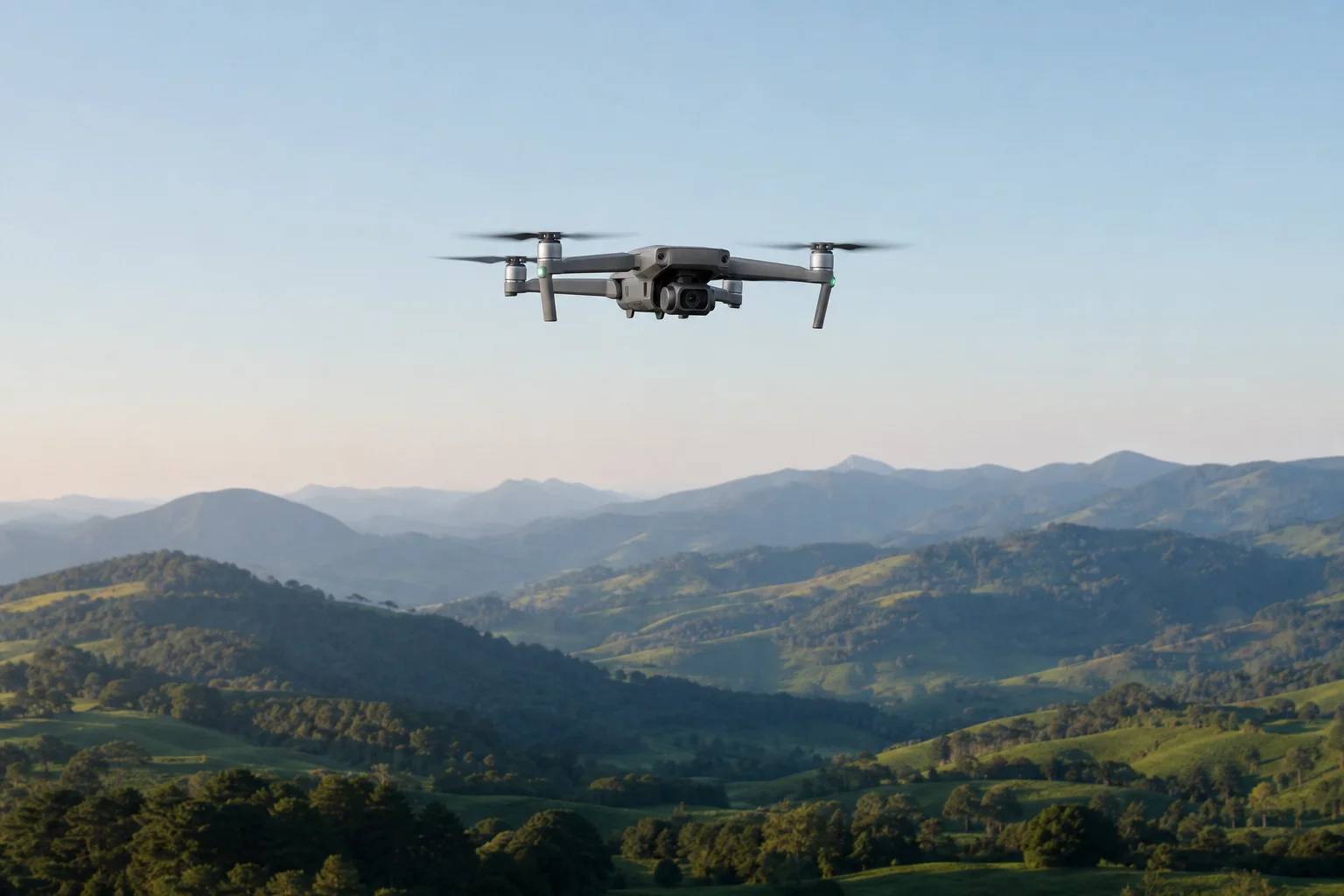 Drone hovering above landscape with hills and mountains