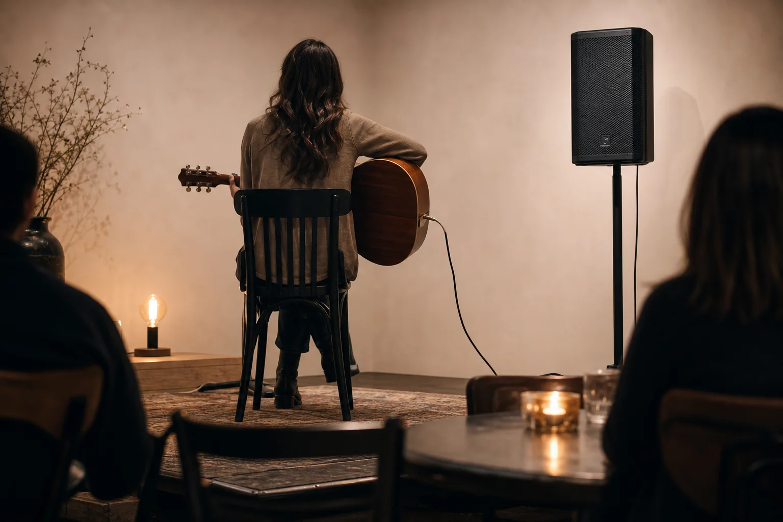 Intérprete acústico solista con un altavoz PA compacto en un soporte en un local pequeño