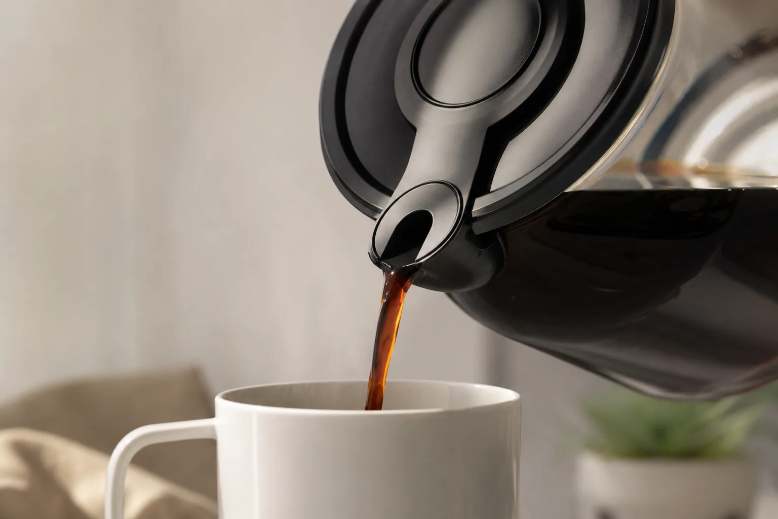 Primo piano della caraffa antigoccia Bunn che versa il caffè in una tazza bianca