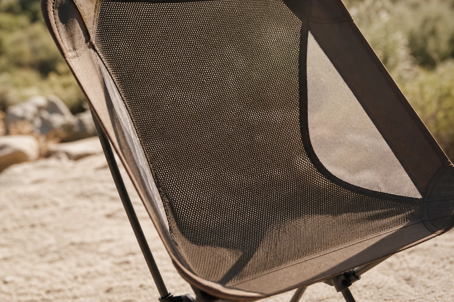 Netz-Campingstuhl im Sonnenlicht, der die atmungsaktive Gewebekonstruktion zeigt