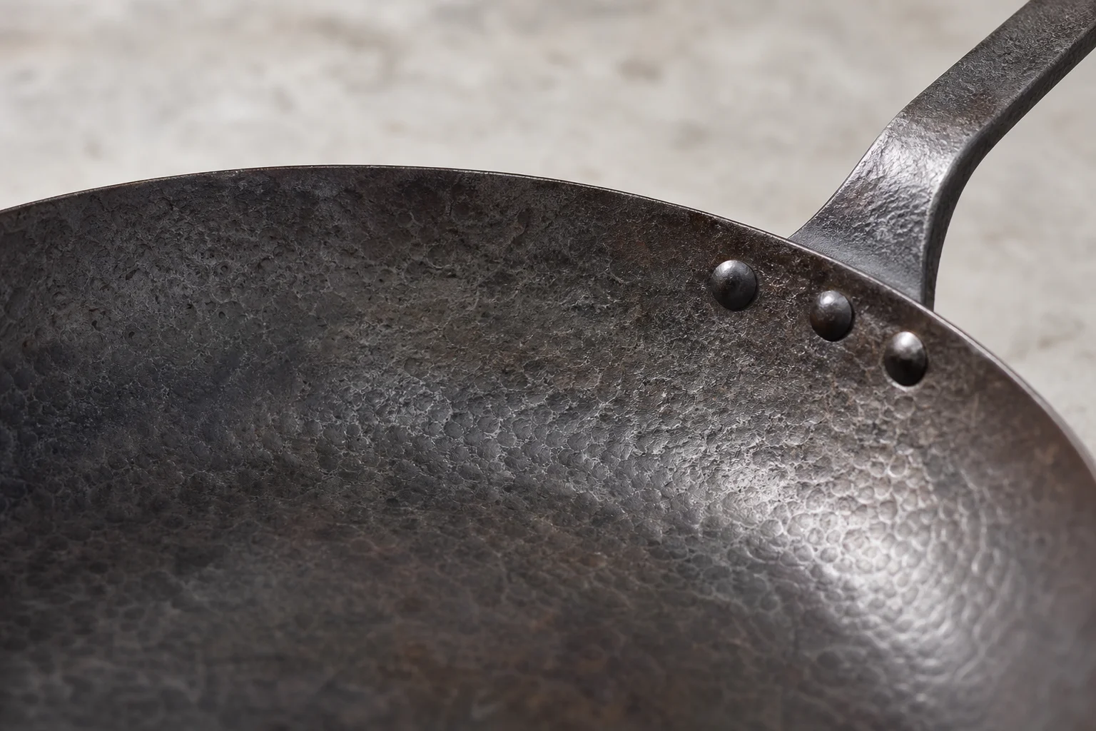 Hand-forged carbon steel pan with hammered texture detail