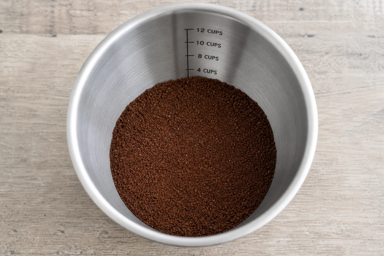 Measuring cup with ground coffee and measurement markings visible