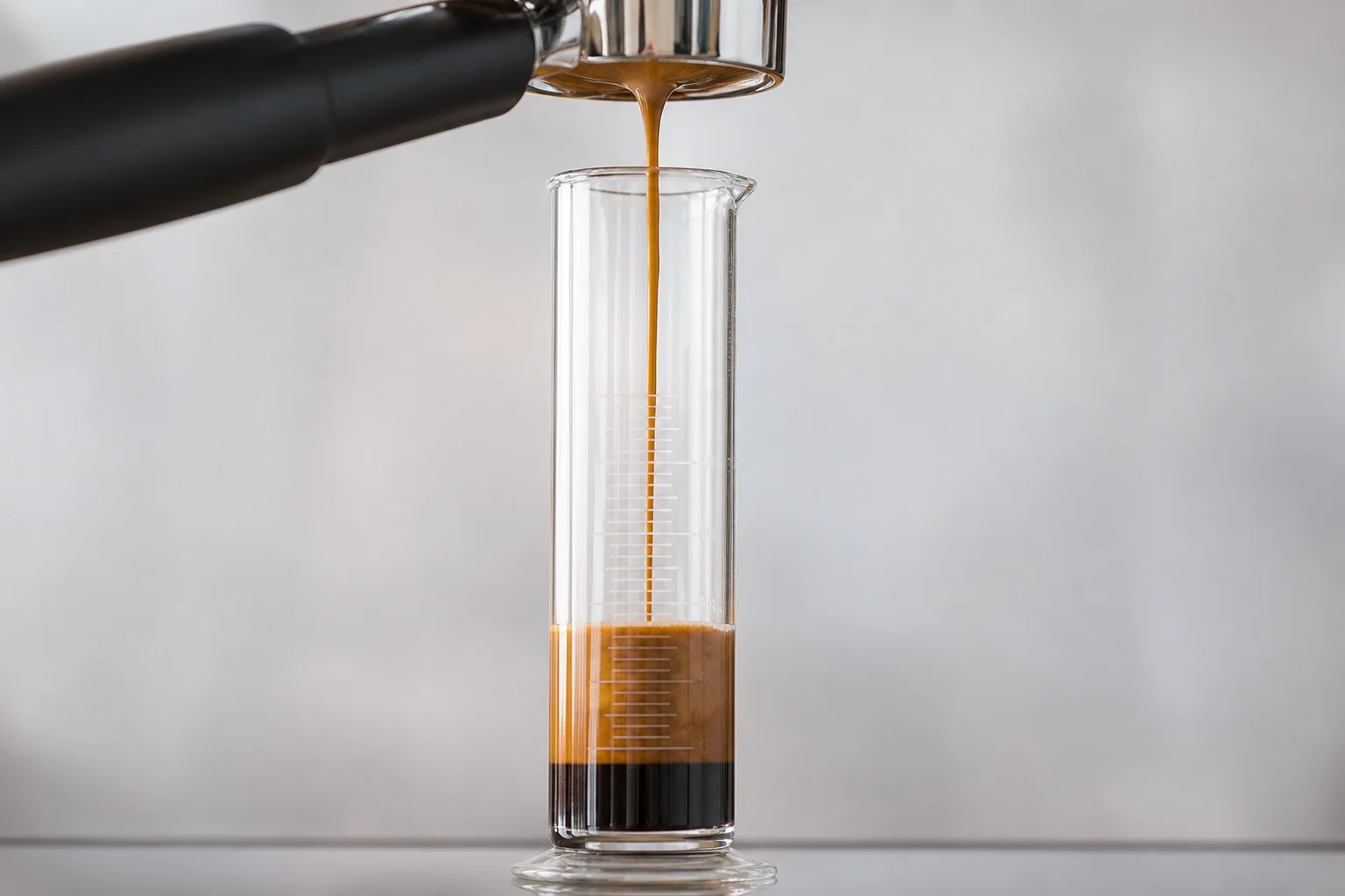 Espresso shot being pulled into a graduated cylinder for measurement