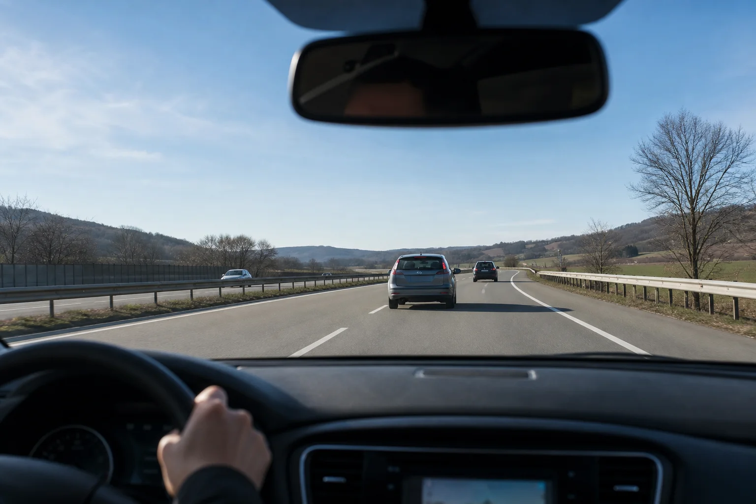 Vista dal cruscotto attraverso il parabrezza dell'auto che mostra la strada e il traffico