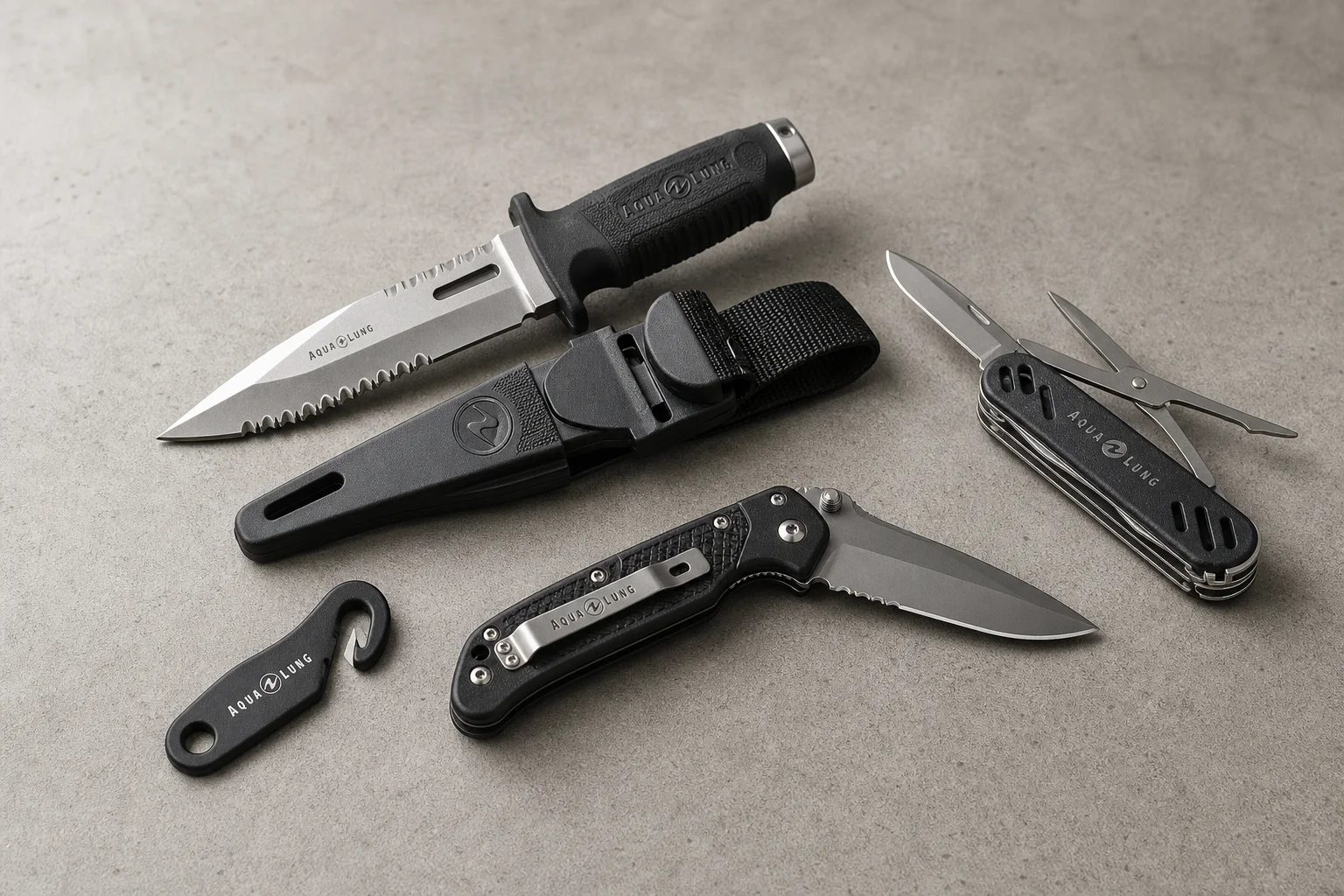 Collection of dive knives and cutting tools on concrete surface