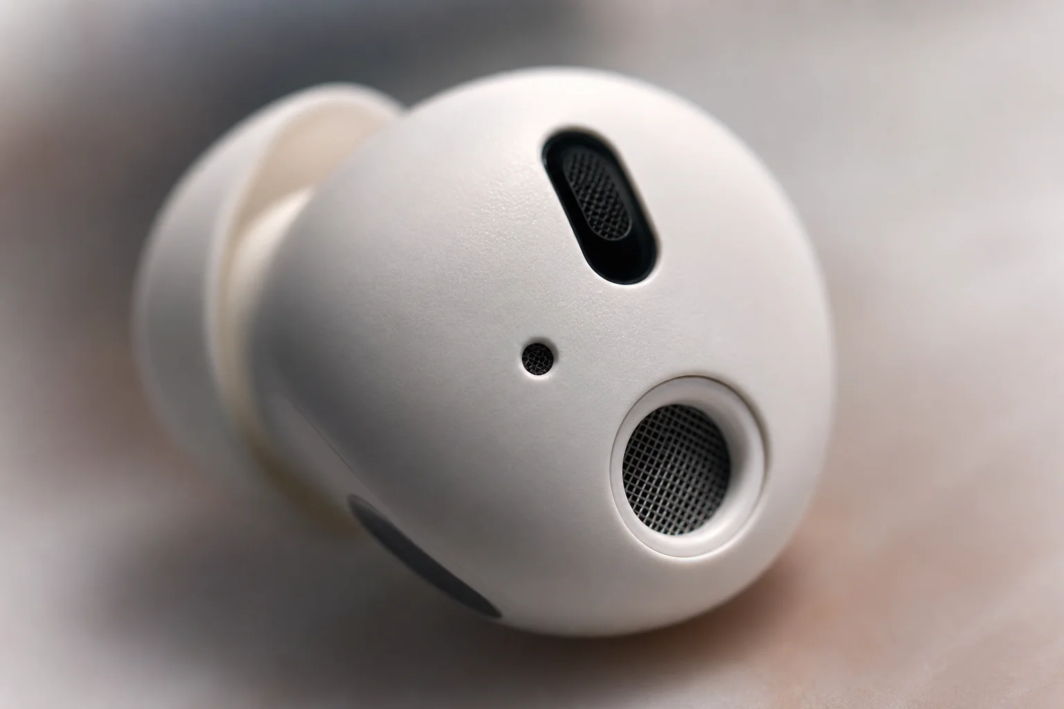 Nahaufnahme des Mikrofonnetzes und der Noise-Cancelling-Details eines In-Ear-Kopfhörers
