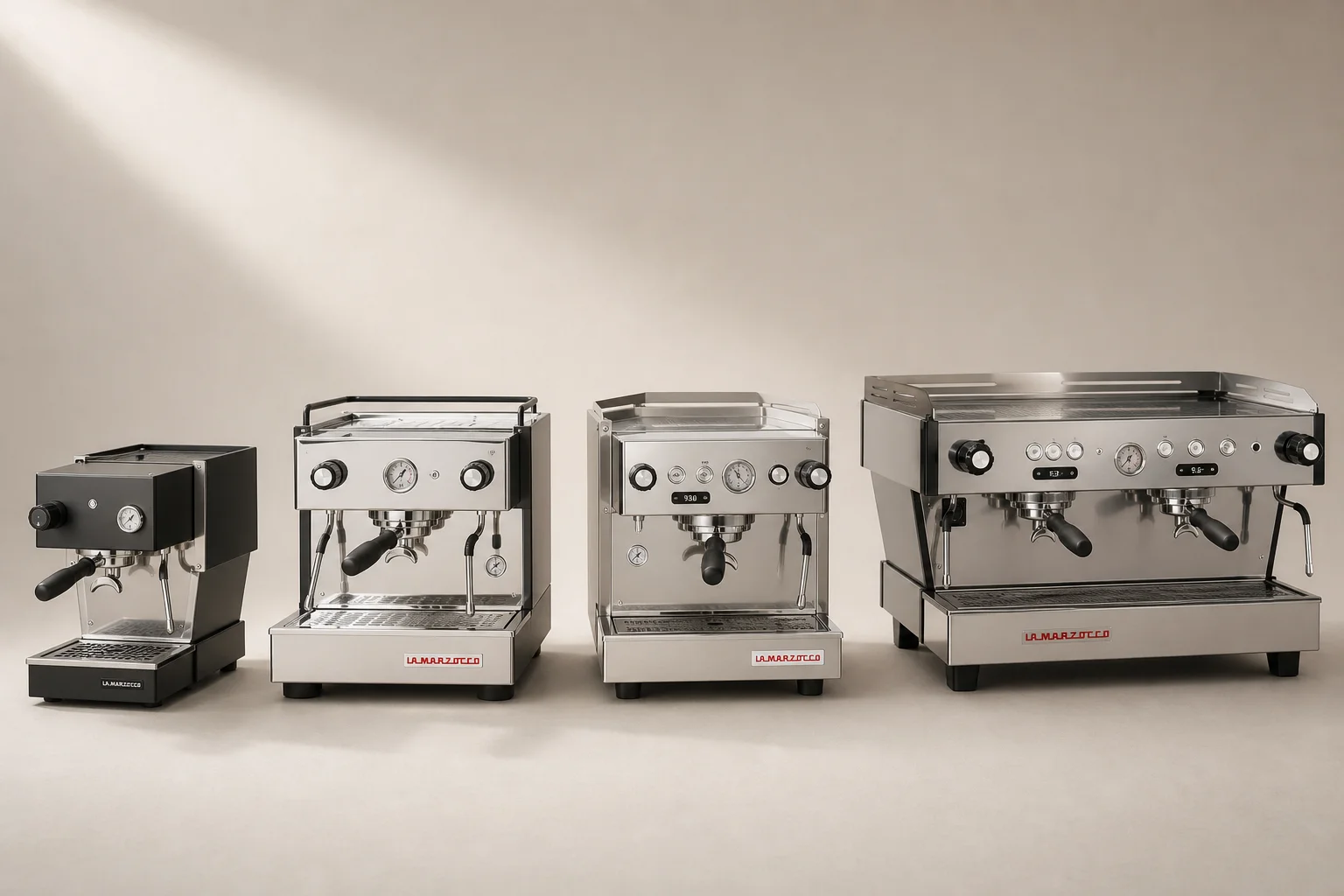 Four espresso machines arranged by size and type on neutral backdrop