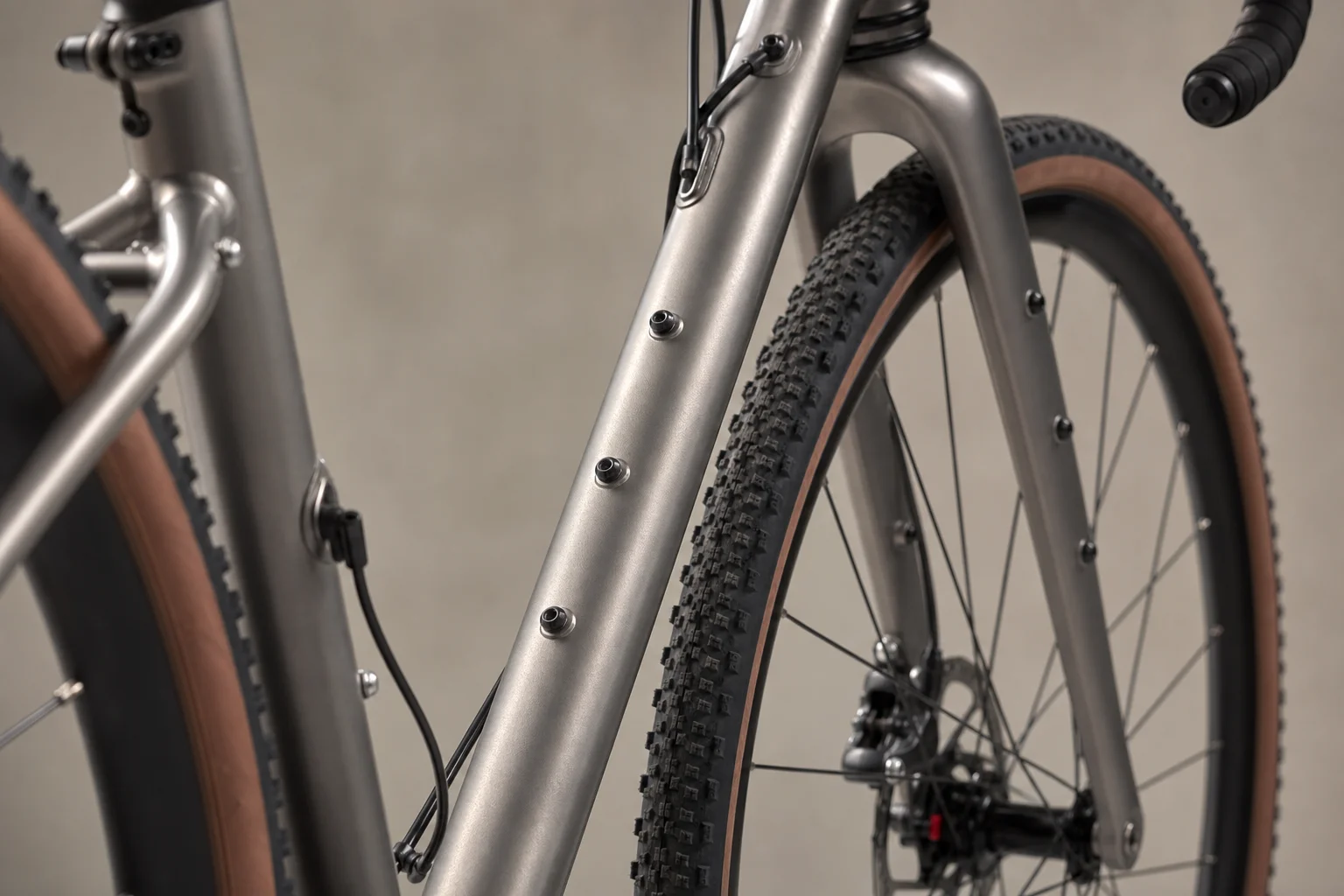 Dettaglio ravvicinato del telaio di una bici gravel che mostra i numerosi punti di fissaggio per portapacchi e borse