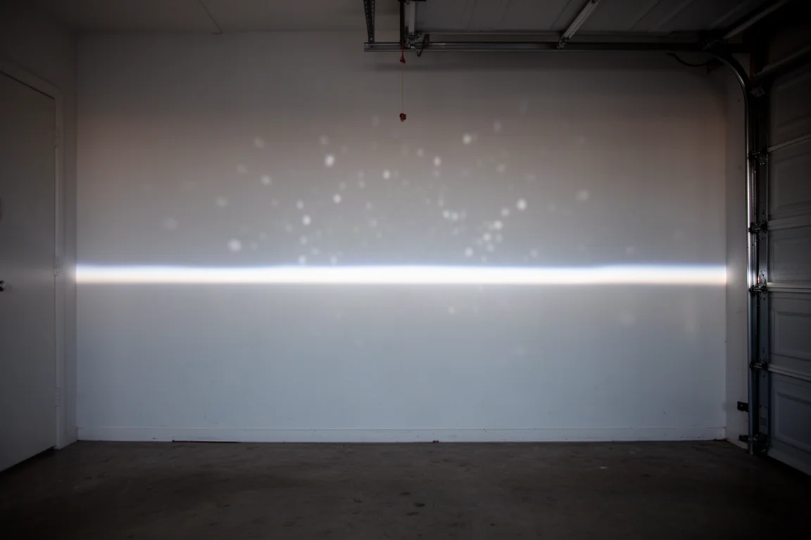 Car headlight beam pattern projected on a wall at night