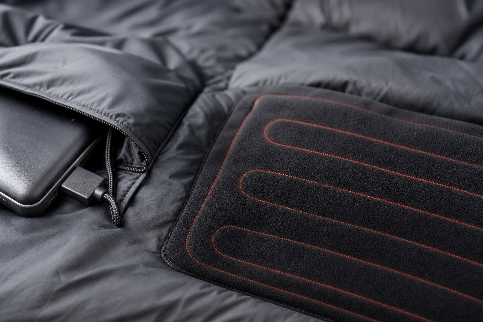 Close-up of USB power connection and heating pad detail on a sleeping bag
