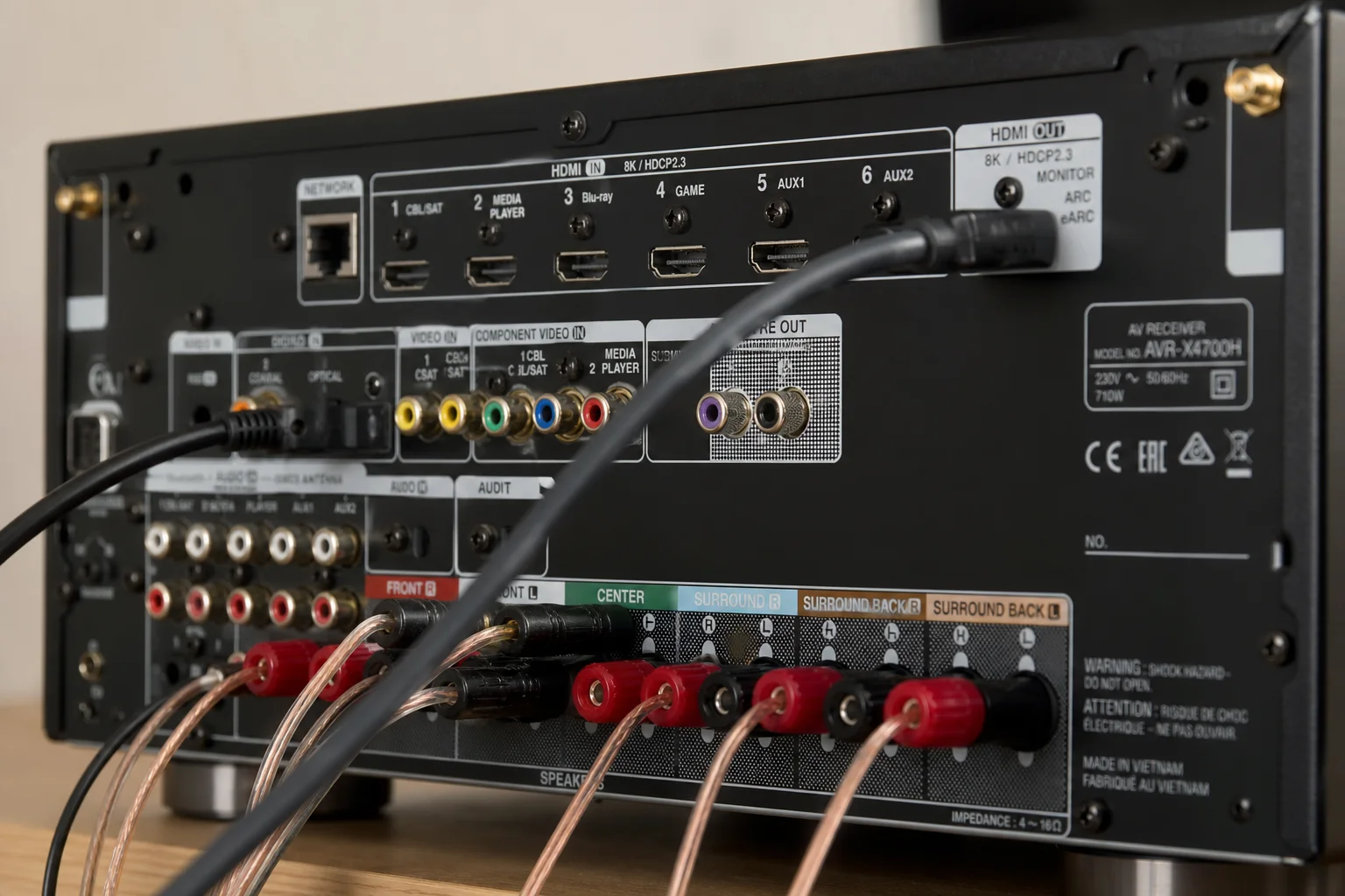 Primo piano di cavi HDMI e connettori audio sul pannello posteriore di un sintoamplificatore