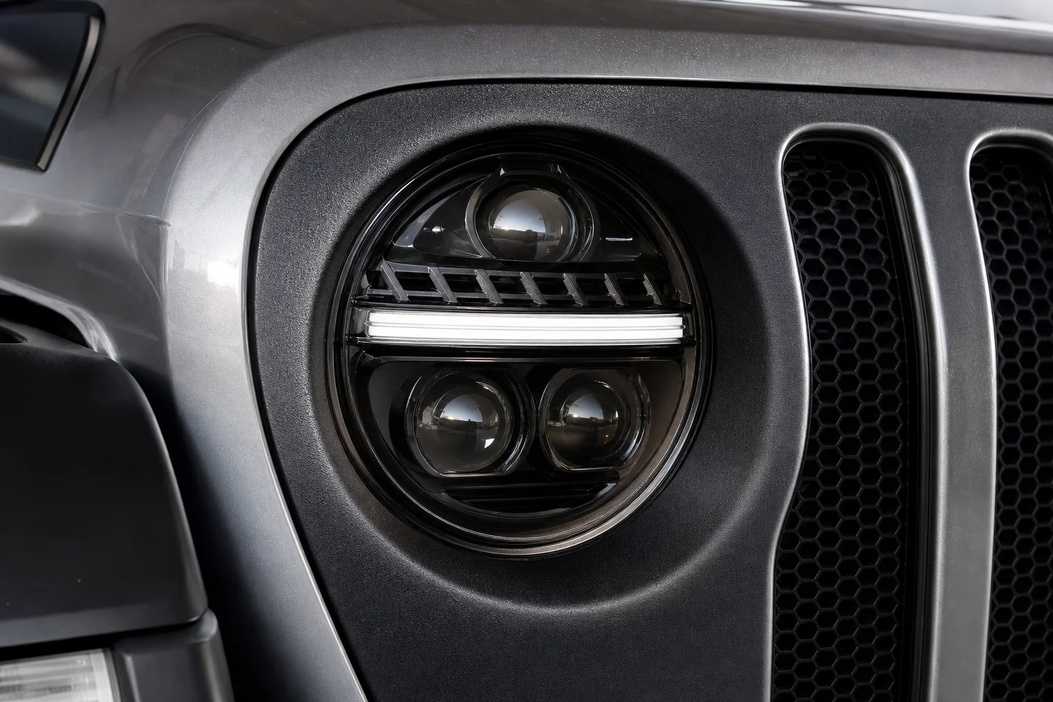 Truck-Lite projector LED headlight mounted in Jeep bezel showing lens detail