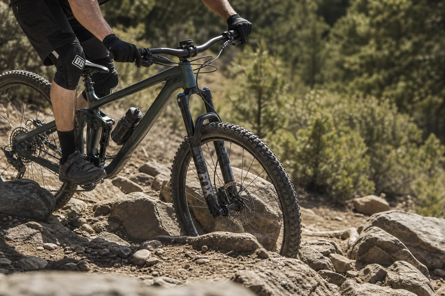 Mountain biker navigating a technical rocky section with hands visible on bars