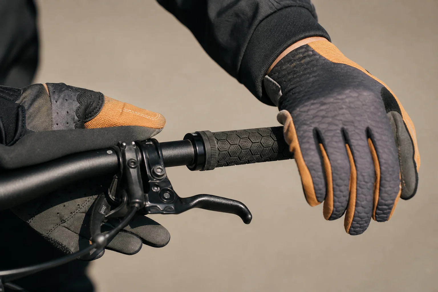 Hände eines Mountainbikers am Lenker, die den Griff und die Polsterung des Handschuhs zeigen