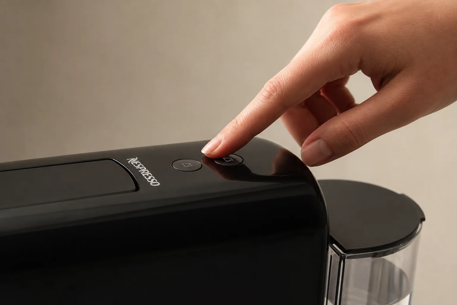 Hand drückt Tasten an einer kompakten Nespresso-Maschine