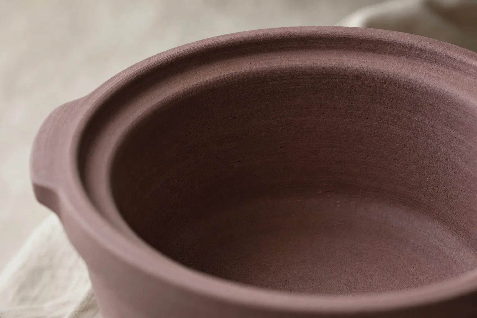 Interno in argilla viola naturale della pentola della slow cooker che mostra la superficie organica non smaltata