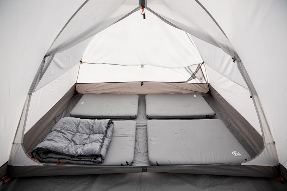 Due materassini larghi stesi fianco a fianco sul fondo di una tenda da backpacking