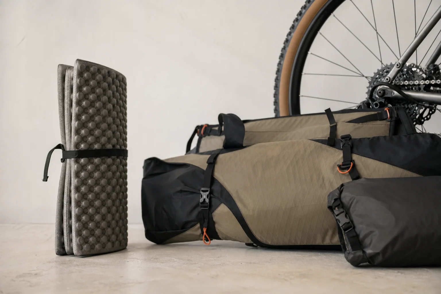 Colchoneta de espuma enrollada y guardada junto a una configuración de bikepacking